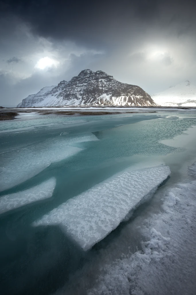 Dédales glacés entourant une montagne enneigée en Islande, juste avant une tempête de neige, photographie d'art de Jill Pollock, Vaea Designs