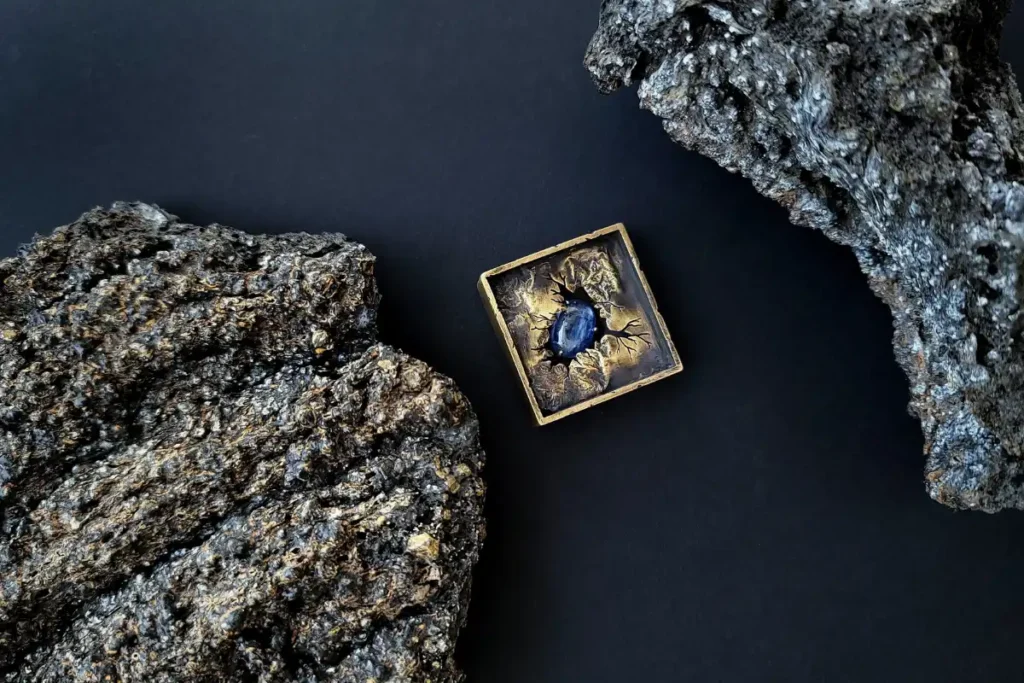 bijou artisanal en laiton photographié sur un fond d'ardoise pour mettre en valeur sa matière